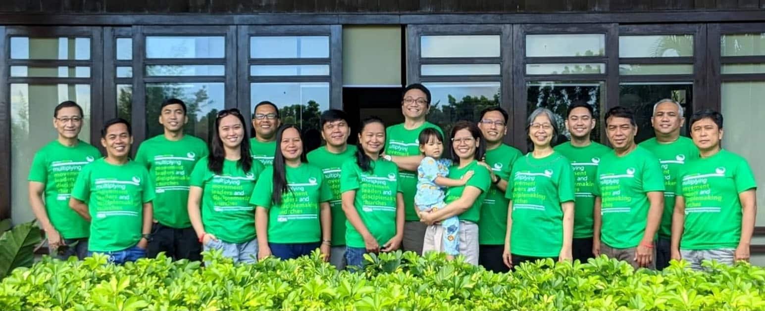 A group of people in green t - shirts posing for a photo.