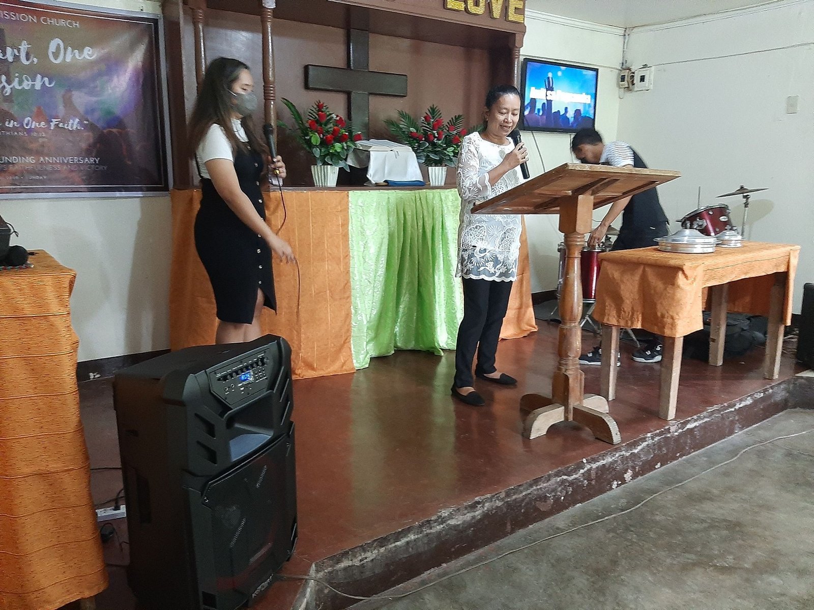 A woman standing at a podium in front of a group of people.