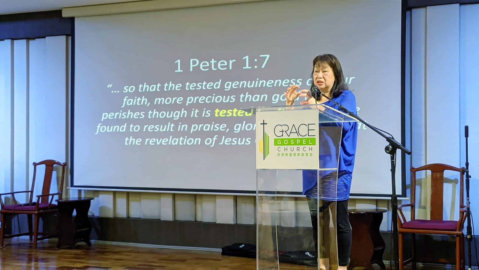 A woman speaking at a podium during the T-Net Philippines National Gathering, in front of a screen.