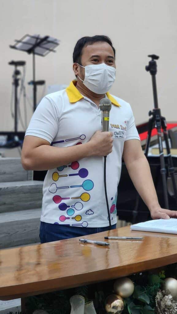 A man wearing a face mask and holding a microphone.