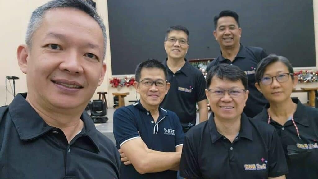 A group of men in black shirts posing for a photo.