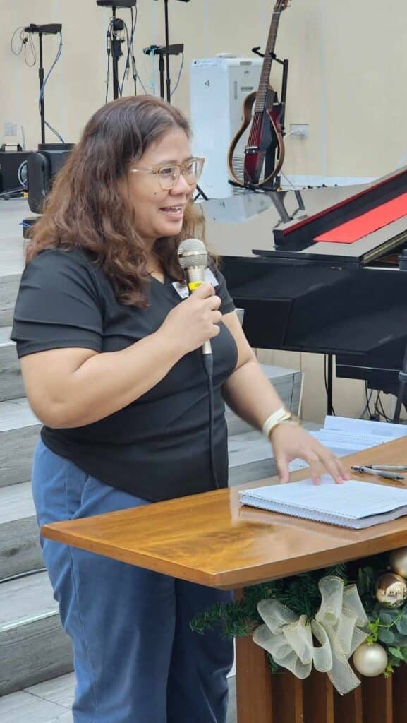 A woman standing in front of a piano with a microphone.