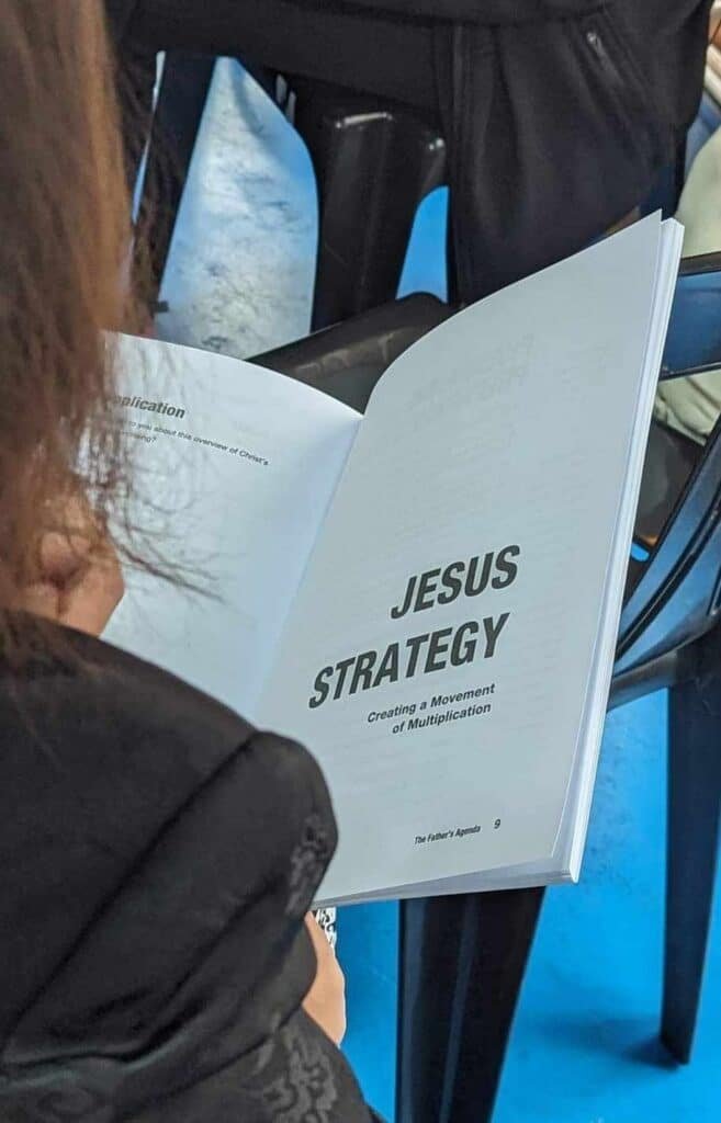 A woman is reading a book about jesus strategy.