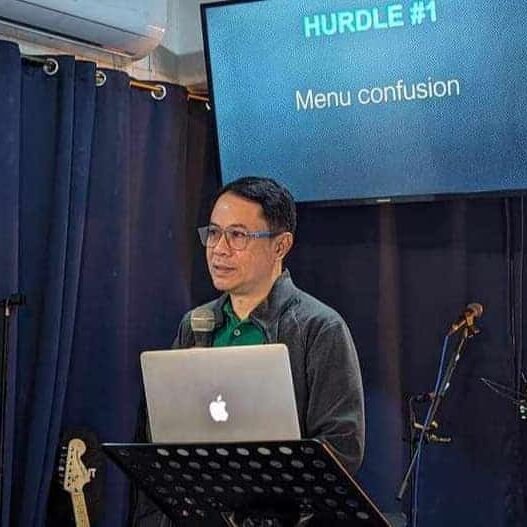 A man standing in front of a stage with a laptop.